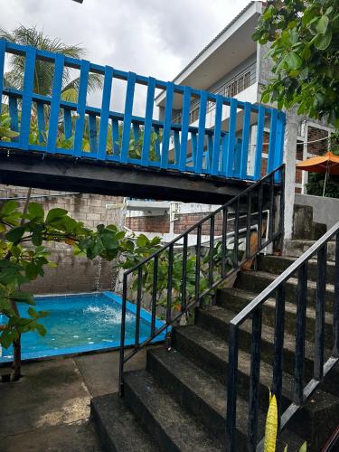 a blue bridge over a stairs next to a swimming pool at Hotel Silver Lake in Santa Ana
