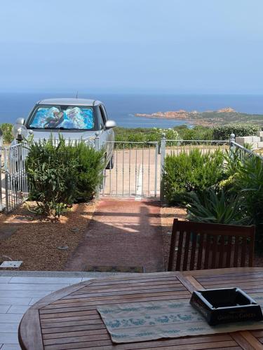 a patio with a table and a car parked next to a fence at Da Marta Appartamento VISTA MARE MOZZAFIATO ISOLA ROSSA in Cascabraga