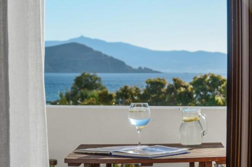 a glass of wine on a table with a view of the ocean at Galaxy Hotel Naxos in Naxos Chora