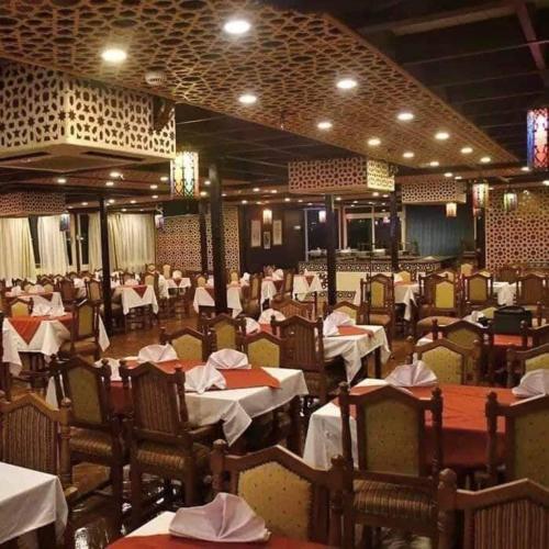a dining room filled with tables and chairs with white tables at الباخرة ريفر بوت in Cairo