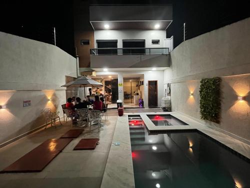 a pool in a building with people sitting at a table at Casa Gravata in Gravatá