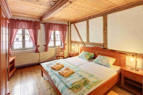 a bedroom with a bed and two windows at Hradní Bašta in Bečov nad Teplou
