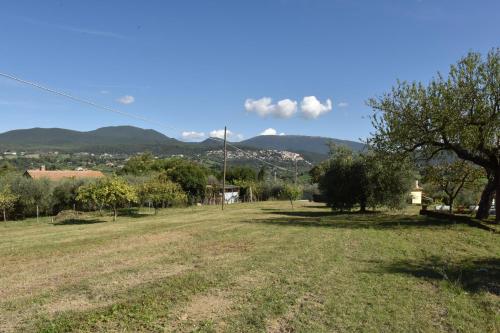 a field with trees and mountains in the background at Il Casale Delle Rose in Colle Micotti