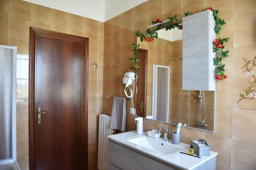 a bathroom with a sink and a mirror at Il Casale Delle Rose in Colle Micotti