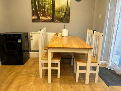 mesa de madera y sillas con mesa y microondas en JM cozy double room with huge garden, en Wainscot