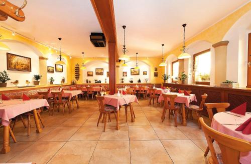 um restaurante com mesas e cadeiras num quarto em Gasthaus& Pension Zum Roten Haus em Bad Schandau