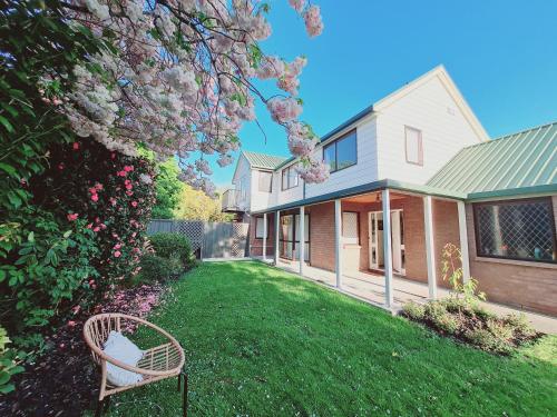 a yard with a chair in front of a house at Homestay near CHC Airport - 2 rooms in Christchurch