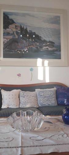a bed in a room with a painting on the wall at Tsitsinakis Traditional Home in Hydra