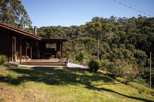 una casa en una colina con un gran patio en Pousada Recanto da Gruta, en Urubici