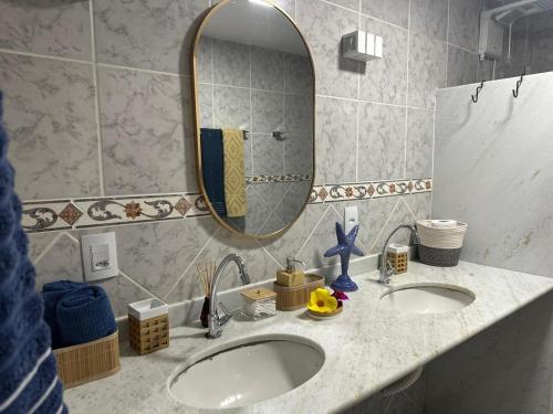 a bathroom with two sinks and a mirror at Beach Life Mirante dos Golfinhos in Nísia Floresta