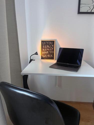a laptop computer sitting on a desk with a chair at APARTMA JEREBIKA ŠT. 20 in Pohorje