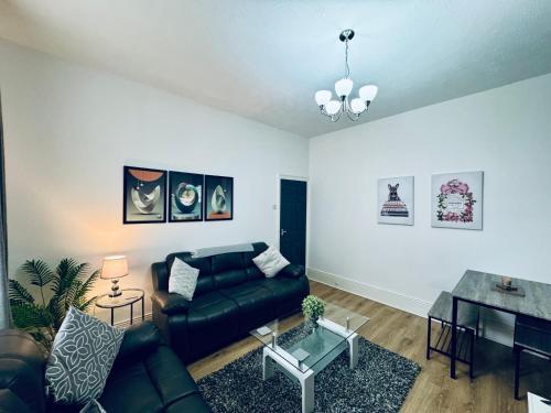 a living room with a couch and a table at Belford Apartment 1, Close to Tynemouth in Tynemouth
