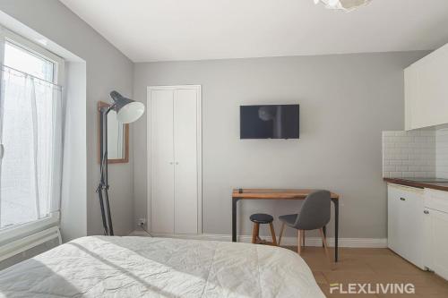 une chambre avec un lit, un bureau et une chaise dans l'établissement Chabrol - Beautiful bright and fully equipped T1, à Paris