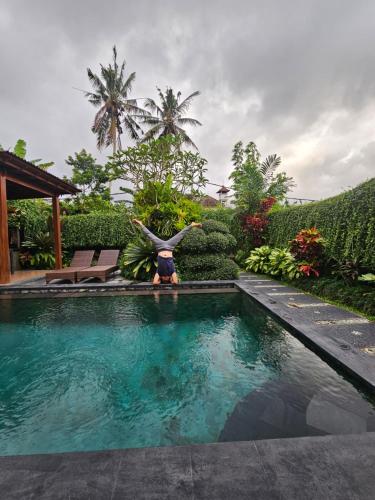 a person is standing in front of a swimming pool at Ubud Paradise Villa in Ubud
