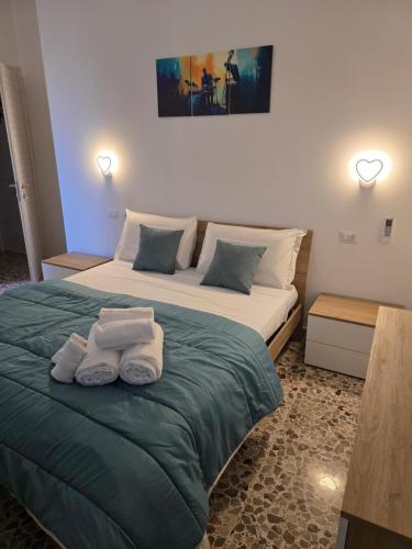 a bedroom with a large bed with towels on it at THAT'S LOVE Fiumicino Jazz in Fiumicino