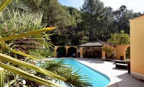 une maison avec une piscine dans une cour dans l'établissement LES RESTANQUES Villa avec piscine, à Cuges-les-Pins