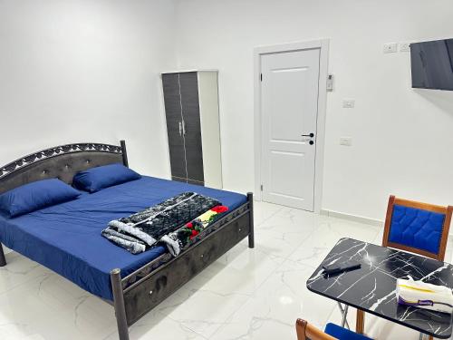 a bedroom with a bed with blue sheets and a table at Steele honey in Jericho