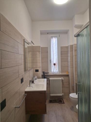 a bathroom with a sink and a toilet and a window at La casa di Susy - Casa Vacanze in Viterbo