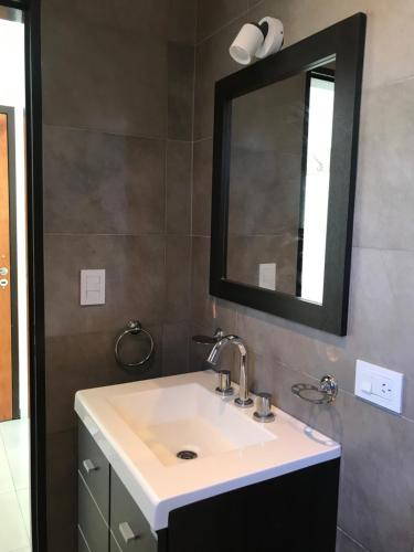 a bathroom with a sink and a mirror at Departamento Barrio Plaza Colon in Chivilcoy