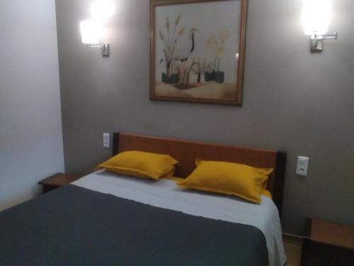 - une chambre avec un lit et 2 oreillers jaunes dans l'établissement Maison L'Oranger avec piscine - Domaine E Case di Cuttoli, à Cuttoli-Corticchiato