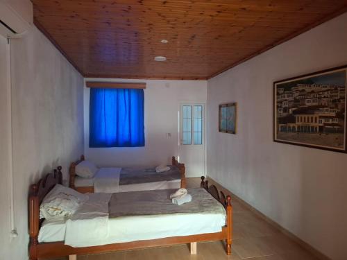 two beds in a room with a blue window at Twin Penthouse in Konizbaltë