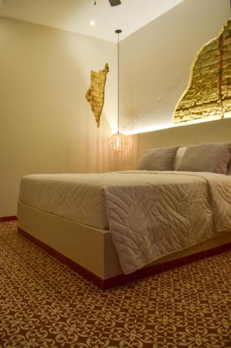 a bedroom with a large bed with a light on the wall at Casa Zoé Hotel Boutique in Villeta