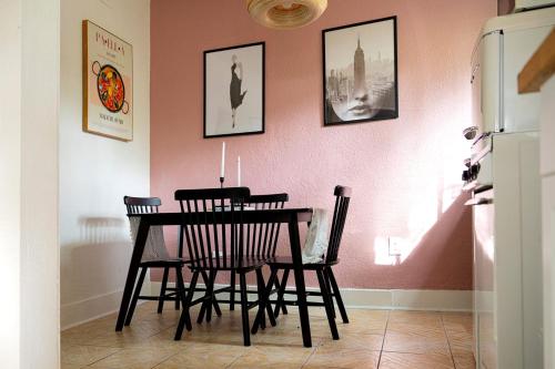 a dining room table with chairs and a pink wall at Historic Orlando Casita Love Apt A with backyard in Orlando