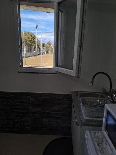 a kitchen with a window and a sink and a field at Il Quadrifoglio House Airport in CTA