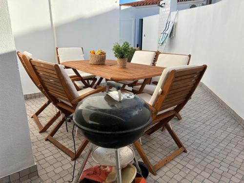 a room with a table and chairs and a grill at Casa do Reguingas in Campinho