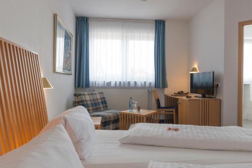 a hotel room with a bed and a television at Hotel Gasthof Zum Storch in Schlüsselfeld