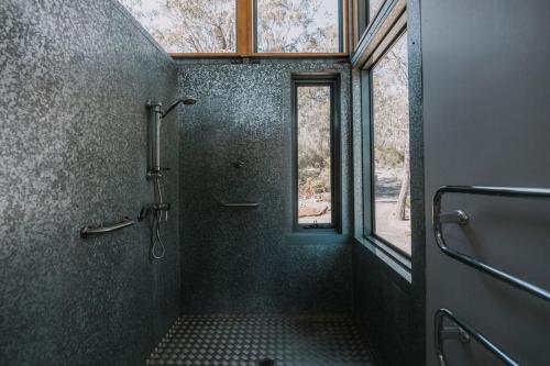a large bathroom with a shower and a window at Wildacres Luxe 40 Acre Australian bush escape with private cliffs in Blackheath