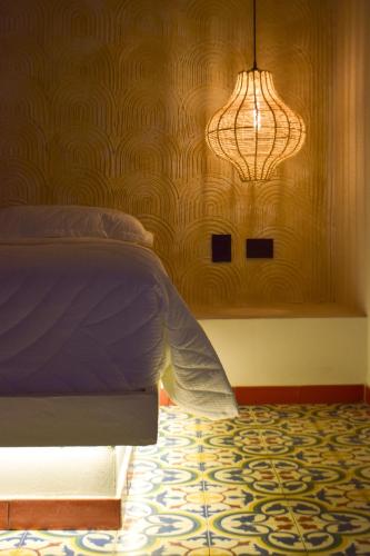 a bedroom with a bed and a chandelier at Casa Zoé Hotel Boutique in Villeta