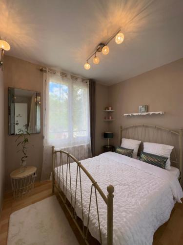 une chambre avec un grand lit et une fenêtre dans l'établissement Dolce casa Maison familiale, à Dourdan
