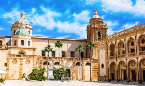 a large building with a clock tower and a church at IL Casale di Petrosino in Petrosino