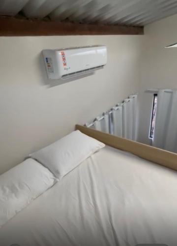 a bed in a room with a air conditioner on the wall at Brisa - Praia da Pipa in Pipa