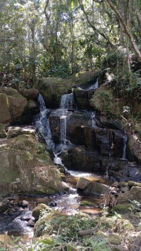 a waterfall on the side of a river with rocks at Suite 5 in Nova Friburgo