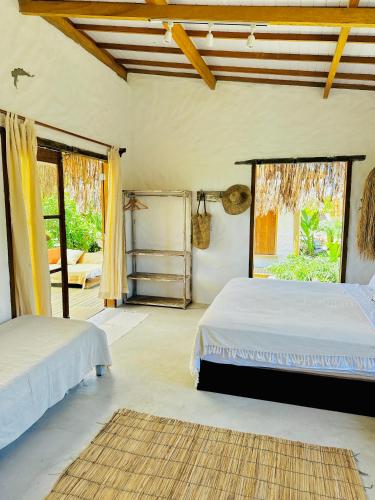 a bedroom with two beds and a window at Vila Alto do Rio Caraíva in Porto Seguro