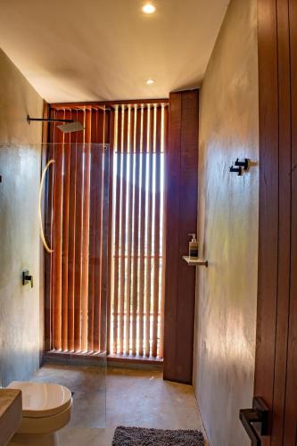 ein Badezimmer mit Toilette und großem Fenster in der Unterkunft Hotel Anukwe in Bonda