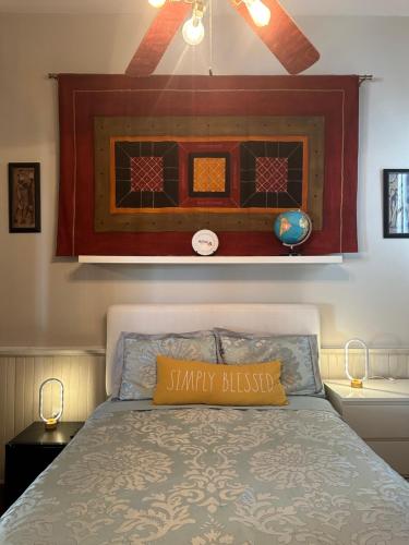 a bed with a yellow pillow on top of it at Creole Cottage Uptown in New Orleans