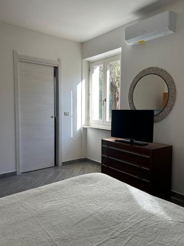 a bedroom with a bed and a mirror and a television at Rural Apartment 44 in Alghero
