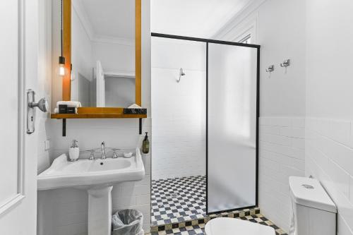 a white bathroom with a sink and a toilet at The Houston Boutique Hotel Wagga in Wagga Wagga