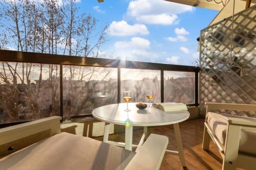 - un balcon avec une table et deux verres de vin dans l'établissement Le Magali - Hypercentre - Parking - Spacious - AC, au Cannet