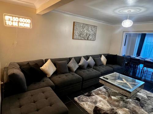 a living room with a couch and a coffee table at Luxurious Cozy London Holiday Home in Cranford