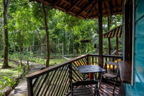 a wooden porch with a table and chairs on it at TerrAmor Ecoliving in Alter do Chao