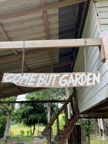 a sign that says one but garden hanging from a porch at Kom buds garden in Ko Yao Noi