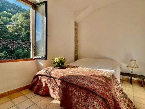une chambre avec un lit et une grande fenêtre dans l'établissement Le Buis Domaine, à Saint-Sauveur-de-Montagut