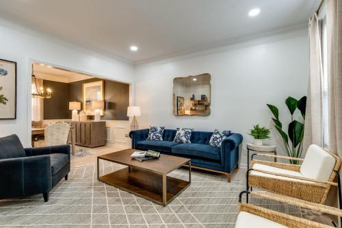 Una sala de estar con sofás azules y una mesa. en Beautiful Sleek and Modern 4 bdrm, en Franklin
