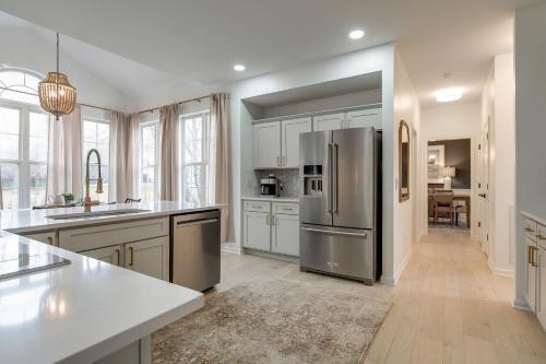 una cocina con nevera de acero inoxidable y armarios blancos en Beautiful Sleek and Modern 4 bdrm, en Franklin