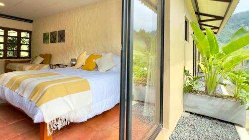 a bedroom with a bed and a balcony at Hotel Mandalay 1941 in Pereira