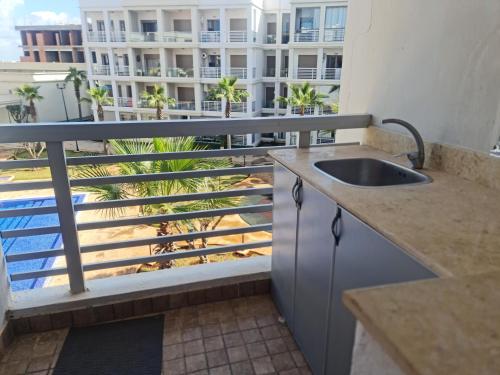 a balcony with a sink and a view of a building at superbe appartement vue piscine in Bouznika